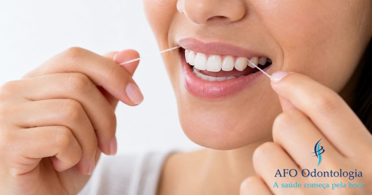 Fio dental sendo utilizado na limpeza interdental — técnica correta para prevenir cáries, Taboão da Serra