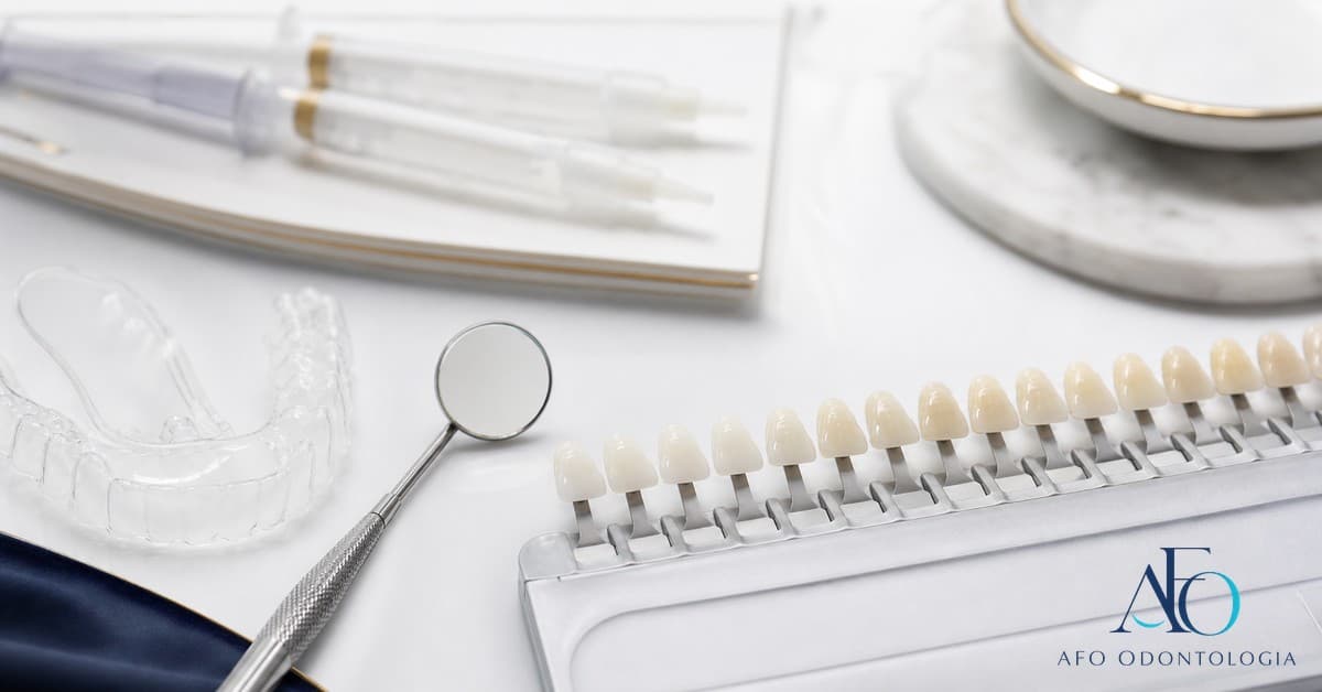 Sorriso claro ao lado de escova de dente e copo de água sobre bancada clínica, ilustrando clareamento dental natural em Taboão da Serra